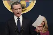  ?? RICH PEDRONCELL­I — THE ASSOCIATED PRESS ?? Gov. Gavin Newsom displays a bill that shields abortion providers and volunteers in California from civil judgements from out-of-state courts in Sacramento, on June 24.