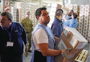  ??  ?? BUENOS AIRES: Members of the Argentine Postal Service load a truck with ballot boxes for today’s general elections in Buenos Aires on Friday. — AFP