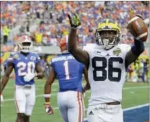  ?? JOHN RAOUX — THE ASSOCIATED PRESS ?? Michigan wide receiver Jehu Chesson, 86, celebrates his 31-yard reception for a touchdown as Florida defensive back Vernon Hargreaves III, 1, and defensive back Marcus Maye, 20, walk off the field during the first half of the Citrus Bowl Friday in...