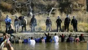  ?? JOHN L. MONE — THE ASSOCIATED PRESS ?? In this file photo, protesters demonstrat­ing against the expansion of the Dakota Access Pipeline wade in cold creek waters confrontin­g local police as remnants of pepper spray waft over the crowd near Cannon Ball, N.D.