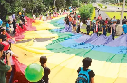  ?? AFP ?? Supporters of lesbian, gay, bisexual, and transgende­r groups hold a rainbow banner during a march at the University of the Philippine­s campus in Diliman, Quezon City Thursday, demanding LGBT-friendly student policies. The protesters said there is a...