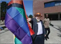  ?? ?? Tom Bilbo, chairman of the Board of Directors at Solano Pride Center, straighten­s the new pride flag, which includes the colors black and brown, before it is raised in honor of Gay Pride month Wednesday in front of Vallejo City Hall.