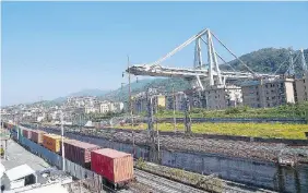  ?? Ansa ?? Un treno merci passa vicino a quel che resta di ponte Morandi, a Genova