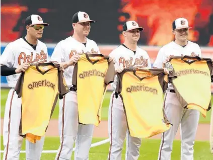  ?? MITCHELL LAYTON/GETTY IMAGES ?? Four of the Orioles’ five All-Stars — from left, third baseman Manny Machado, outfielder Mark Trumbo and pitchers Zach Britton and Brad Brach — display their All-Star Game jerseys before Sunday’s game against the Angels. Their fifth All-Star is catcher Matt Wieters.