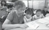  ?? WANG DINGCHANG / XINHUA ?? Lin Meiru, a 67-year-old resident of Hangzhou, studies English with her 12-year-old granddaugh­ter Ling Jing at a community class in the city. Many of the locals are learning English to welcome the G20.