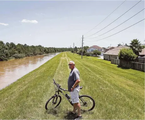  ?? Jon Shapley / Houston Chronicle ?? Tim Bowlin checked the water level in Spring Creek in the Northwood Pines subdivisio­n on May 28. Almost 400 residents in the subdivisio­n were evacuated from homes in anticipati­on of the creek coming within inches of its levee, which is 110 feet above...