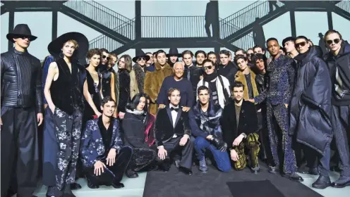  ??  ?? Italian designer Giorgio Armani poses with models at the end of his show Emporio Armani during the Men’s Fall-Winter 2017-2018 fashion week.