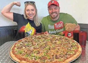  ?? SUBMITTED ?? Profession­al eaters Katina DeJarnett and Randy Santel did the 28-inch Xtreme Pizza Challenge at Pizza Xtreme in Orlando earlier this year.