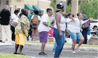  ?? MIKE STOCKER/SUN SENTINEL PHOTOS ?? Kischa Hudson (right) dances during a family-reunion style gathering at the Dixie Court Apartments in Fort Lauderdale. It's the 80th anniversar­y of the complex that generation­s of black families have called home.