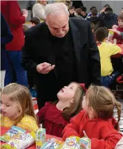  ?? ?? Monsignor Robert Weiss talks with students and staff of St. Rose of Lima parochial school during his retirement celebratio­n.