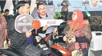  ?? — Photo by Roystein Emmor ?? Rubiah shares a light moment with Muzaidi Mahrop, the grand prize winner of the Mini KUD 2024 Kota Samarahan lucky draw, a er the closing ceremony.
