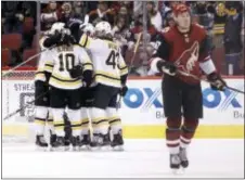  ?? RALPH FRESO — THE ASSOCIATED PRESS ?? Boston’s Anders Bjork (10) celebrates with Danton Heinen (43) and other teammates after scoring a third-period goal as Arizona’s Lawson Crouse skates off the ice.