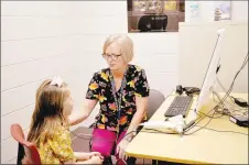  ?? RACHEL DICKERSON/MCDONALD COUNTY PRESS ?? Nurse Melinda Taylor (right) uses a specialize­d instrument to measure Payton Eckman’s heartbeat during a telemedici­ne demonstrat­ion at Rocky Comfort School on Wednesday, Aug. 14.