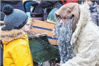  ?? FOTO: FERDINAND LEINECKER ?? Knecht Ruprecht redet ganz freundlich mit den kleinen Besuchern des Ochsenhaus­er Weihnachts­markts.