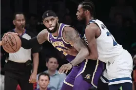  ?? AP FOTO ?? HOME WIN. Los Angeles Lakers forward LeBron James tries to get by Minnesota Timberwolv­es forward Andrew Wiggins.