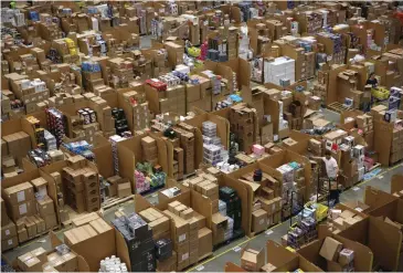  ?? (Neil Hall/Reuters) ?? WORKERS COLLECT customer orders during Black Friday deals week at an Amazon fulfillmen­t center in Hemel Hempstead, England, on November 25, 2015.