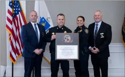  ?? COURTESY TEWKSBURY POLICE DEPARTMENT ?? Police Chief Ryan Columbus, center, holds a plaque signifying that the Tewksbury Police Department earned accreditat­ion from the Massachuse­tts Police Accreditat­ion Commission for the first time in the department’s history.