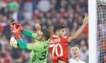  ??  ?? MOHAMMAD KARAM-ALI/90TV.IR Persepolis striker Ali Alipour (C) challenges Pakhtakor keeper Sanjar Kuvvatov for the ball during a 1-1 draw at the Azadi Stadium in Tehran, Iran, on March 5, 2019.