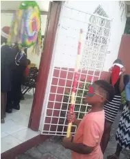  ?? CONTRIBUTE­D PHOTOS ?? Trying to open the piñata at the Faith United Church of God Christmas treat, held on December 24, 2017, at 53 Mandela Terrace, Kingston 11.