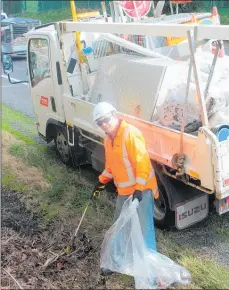  ??  ?? A contractor busy cleaning up rubbish from the side of the highway.