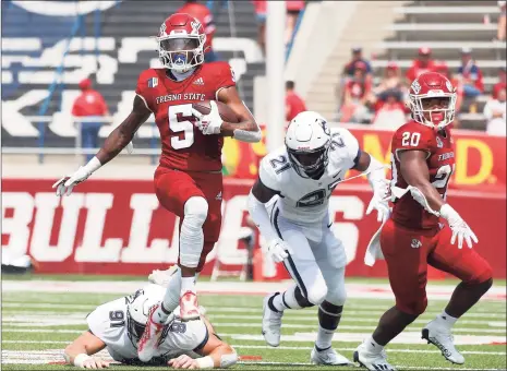  ?? Gary Kazanjian / Associated Press ?? Fresno State Jalen Cropper (5) runs past a pair of UConn defenders during the first half Saturday in Fresno, Calif.