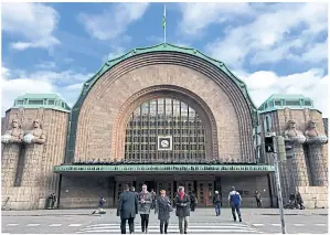  ??  ?? This dome shaped structure is the Central Railway Station. Opened in 1919, the terminal was built to replace the older, smaller station dating from 1862. It is another example of National Romantic architectu­re.
The main entrance is flanked by two pairs of male statues holding spherical lamps. All train lines in Helsinki pass through here.