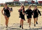  ?? ?? Top, Waimate High School students, from left, Maddie Matthews, 15, Jayla Davis, 14, Alisha Swann, 14 and Emily Cooney, 14, perform the chicken dance challenge during the Caroline Bay amazing race. Left, Geraldine High School students, from left, Georaeah Edmonds-Cooper, 14, Chloe Farquhar, 14, Sepia Allpress, 13, and Summer Snow, 14, run along Caroline Bay. Right, Gabriel Dickerson, 15, of Roncalli College, carries a bag of sand during the amazing race.