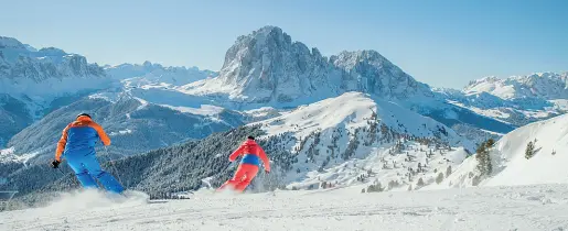  ?? (foto Dolomiti Superski) ?? Stagione invernale Due sciatori in pista, sullo sfondo il Sassolungo