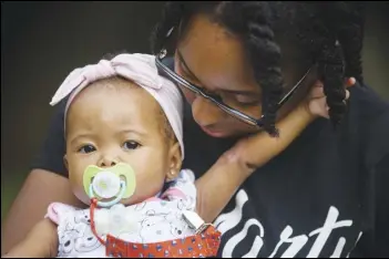  ?? ASSOCIATED PRESS ?? Tyesha Young, who lost her hospital job during the pandemic, holds her baby Jalayah Johnson outside their home in Waggaman, La. More than $7,000 behind on rent, Young had hoped a program in Louisiana would bail her out and allow her family to avert eviction in the coming weeks.