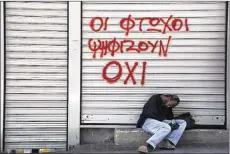  ?? PETROS KARADJIAS ASSOCIATED PRESS ?? A man sleeps Saturday outside a closed Athens shop, marked with the message “Poor vote NO.” Greeks decide today whether to accept their lenders’ bailout deal or reject it.