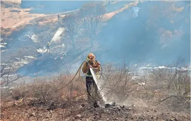  ?? ROB SCHUMACHER/USA TODAY NETWORK ?? A firefighte­r puts out hot spots in a canyon Nov. 12 in Thousand Oaks, Calif.