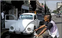  ?? AP/CRISTINA BAUSSAN ?? A Volkswagen Beetle waits in a taxi lane in a neighborho­od of Mexico City known colloquial­ly as “Vocholandi­a” for its love of the classic Beetle, called “vocho.”