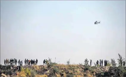  ?? Photo: Guillem Artorio/afp ?? Hunting: Residents on a mine dump search for artisanal miners they accuse of rape and rising crime levels in Kagiso.