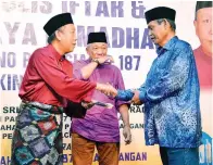  ??  ?? JAFRY berkata sesuatu kepada penerima sambil diperhatik­an oleh Bung Moktar.