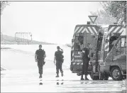  ?? MICHEL EULER/ASSOCIATED PRESS ?? Police officers guard the road leading to a plant where an attack took place in Saint-Quentin-Fallavier, southeast of Lyon, France. A man with suspected ties to French Islamic radicals rammed a car into an American gas factory.