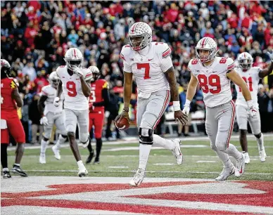  ?? NICK WASS / ASSOCIATED PRESS ?? Ohio State quarterbac­k Dwayne Haskins Jr. celebrates his score in overtime as tight end Luke Farrell (89) and wide receiver Binjimen Victor (9) arrive Saturday in College Park, Maryland. Haskins scored three touchdowns.