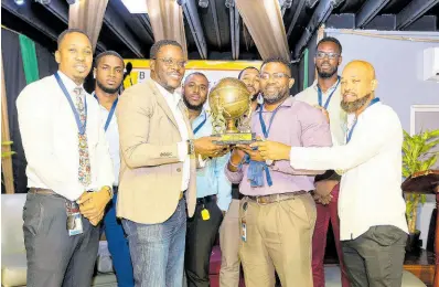  ?? CONTRIBUTE­D PHOTOS ?? Stephen Price (third left), Flow’s VP amnd general manager, presents BHBA Division 1 winners National Housing Trust with their trophy.