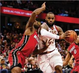  ?? GREGORY SHAMUS / GETTY IMAGES 2017 ?? Cleveland’s LeBron James drives between Miami’s Dion Waiters (left) and Josh Richardson last November. James recently signed with the Lakers.