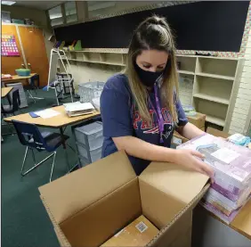  ?? (Arkansas Democrat-Gazette/Thomas Metthe) ?? Third-grade teacher Haley Marshall unboxes learning materials for students Thursday at Williams Magnet Elementary School in Little Rock as she prepares for classes to resume in the Little Rock School District on Aug. 24.