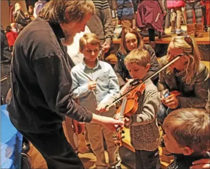  ?? CHRIS BARBER — DIGITAL FIRST MEDIA ?? Violinist Martin Beech helps a child try out the violin after Sunday’s concert in West Chester.