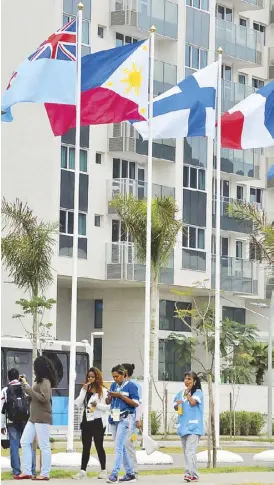  ?? ABAC CORDERO ?? The Philippine flag flutters in the wind inside the Athletes Village as Filipino fighters Rogen Ladon and Charly Suarez (lower photo) arrive in Rio with coach Boy Velasco.