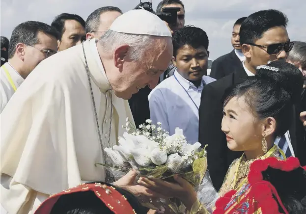  ??  ?? 0 Pope Francis receives flowers on his arrival at Yangon Internatio­nal Airport in Myanmar at the start of his four-day visit