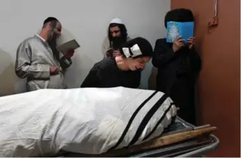  ?? GIL COHEN-MAGEN/AFP/GETTY IMAGES ?? Friends and relatives mourn over the body of Aaron Bennett, a 24-year-old Israeli-Canadian soldier who was killed when a knife-wielding Palestinia­n attacked him and his family in Jerusalem’s Old City.