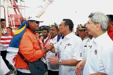  ??  ?? Mission complete: Hishammudd­in greeting one of the participan­ts of the Rohingya aid mission at the Boustead Cruise Centre in Port Klang. On the right is Mah.