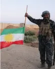  ??  ?? An Iraqi soldier holds the Kurdish flag upside down after his army seized enemy positions in Kirkuk