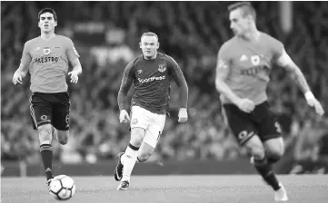  ??  ?? Wayne Rooney (centre) prepares to challenge MFK Ruzomberok’s Kristi Qose (left) during the UEFA Europa League third qualifying round, Game 1 match at Goodison Park football stadium in Liverpool. — AFP photo