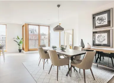  ??  ?? Two similar art pieces stacked on top of each other help make the ceiling of this dining area feel higher.