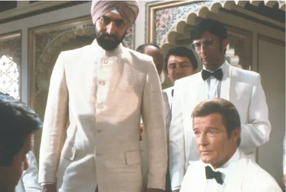  ?? UNITED ARTISTS ?? The henchman Gobinda, played by Kabir Bedi, looks on as British spy James Bond, played by Roger Moore,
takes on supervilla­in Kamal Khan, played by Louis Jourdan, in a scene from the underrated Octopussy.