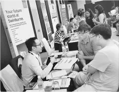  ??  ?? Parents and students obtaining the latest informatio­n from university representa­tives at the fair.