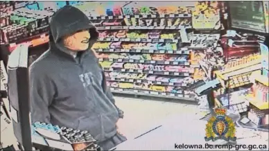  ??  ?? Suspect, with face covered, standing inside convenienc­e store at cash register.